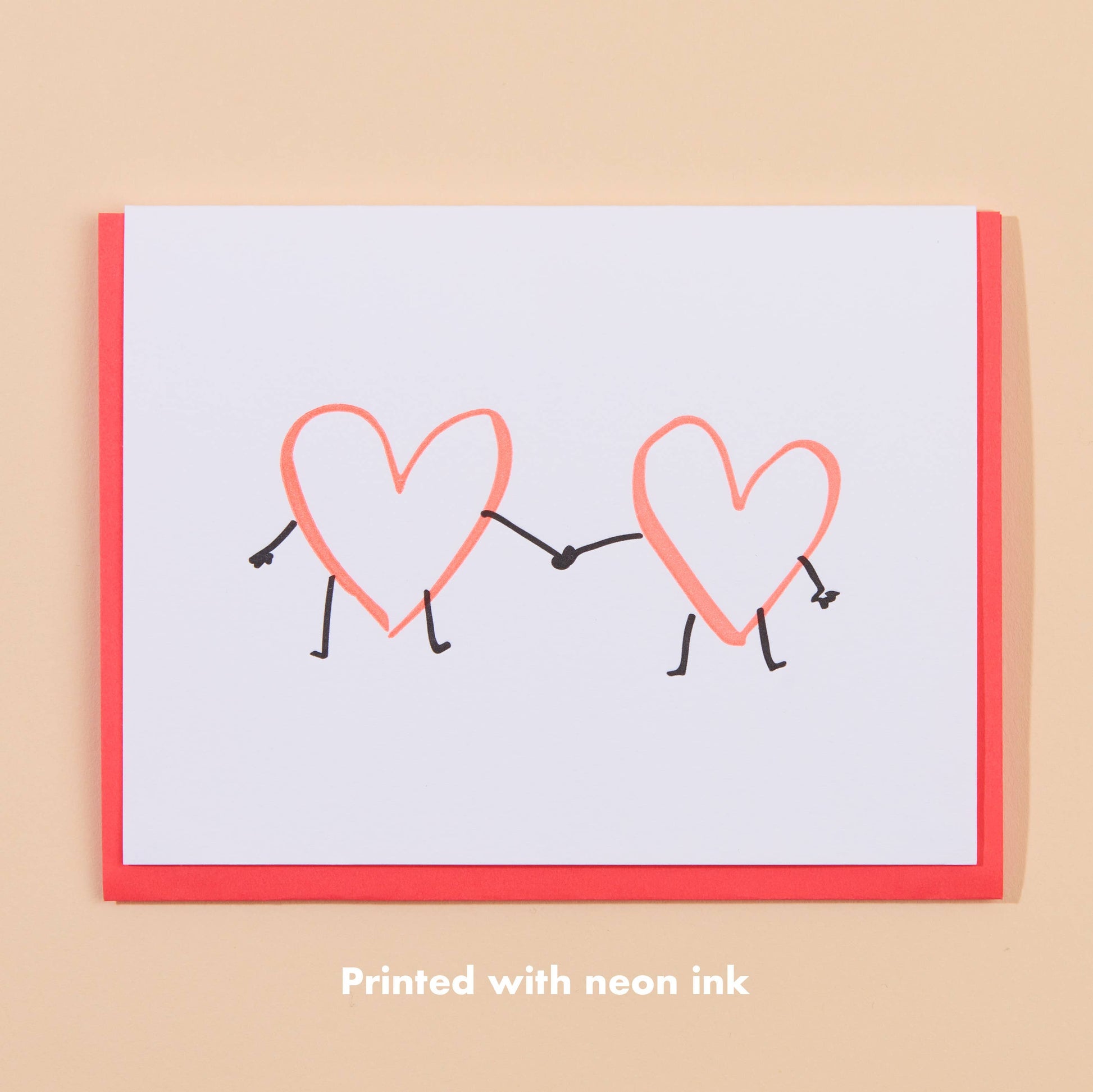 greeting card with two hearts holding hands