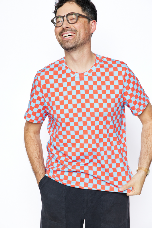 dad standing and laughing while wearing a colorful organic red and blue checker tshirt