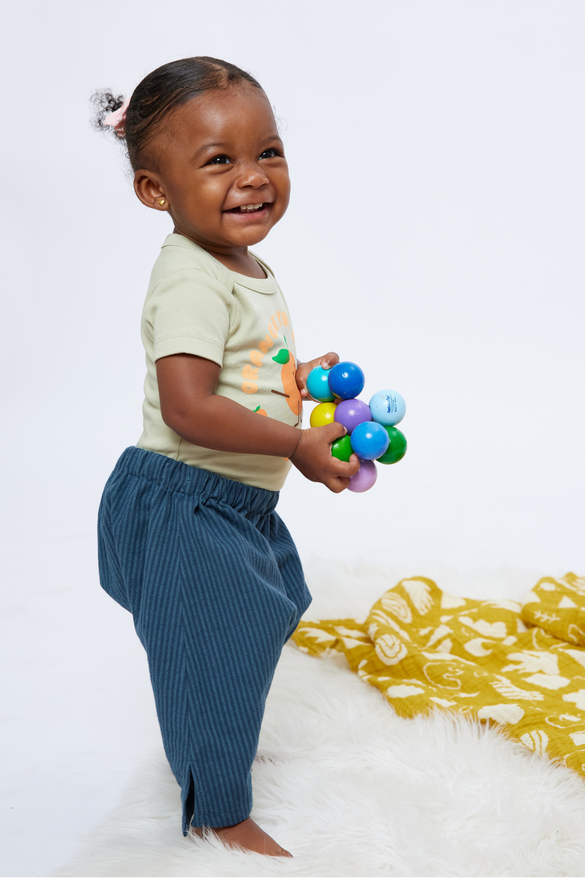 blue striped cotton baby play pants on a 12 month old child